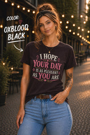 Oxblood Black Bella+Canvas t-shirt featuring the sarcastic quote "I Hope Your Day Is As Pleasant As You Are" in distressed pink and cream typography on a relaxed unisex fit.