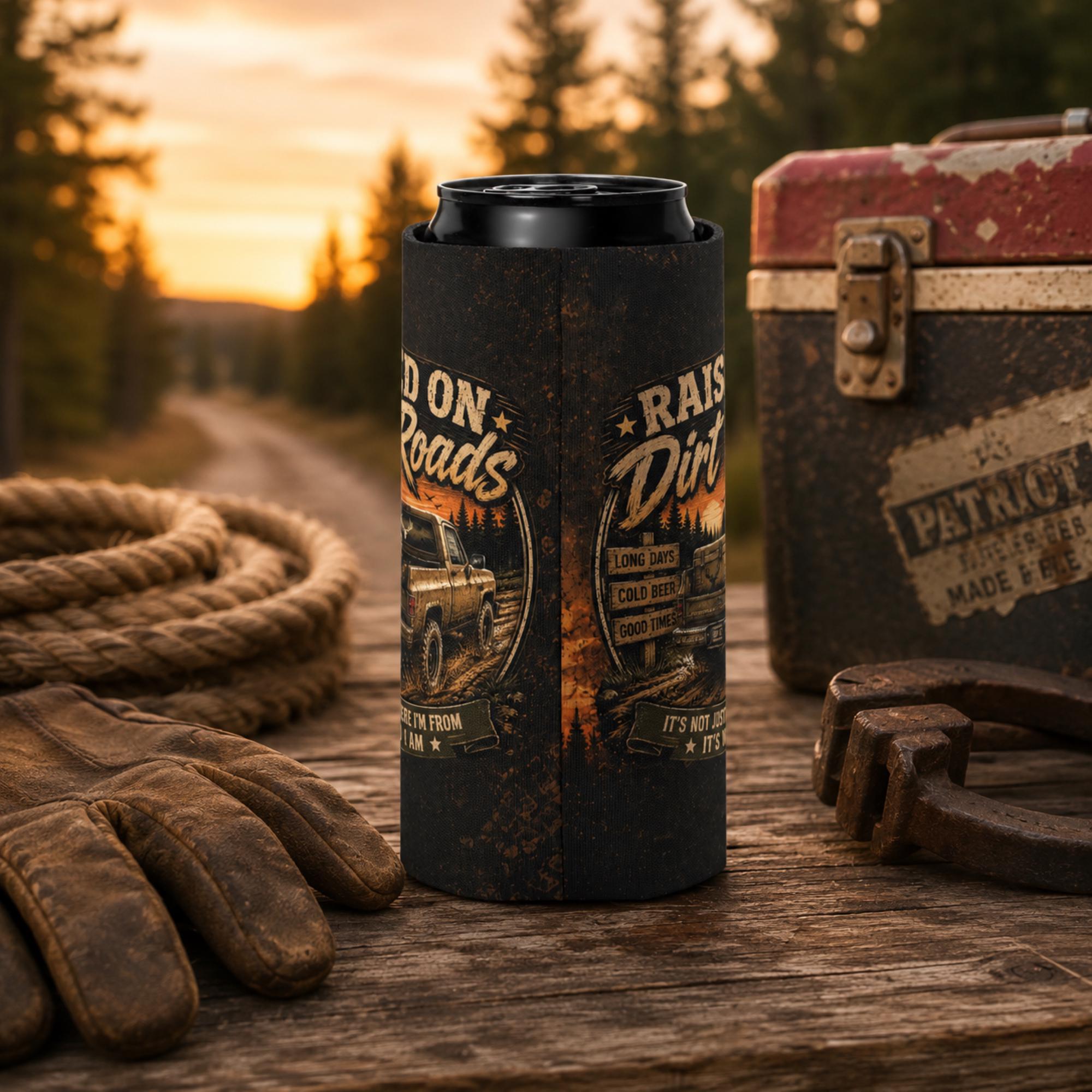 Slim can cooler featuring the "Raised on Dirt Roads" vintage pickup truck design on a rustic tailgate with an old cooler and country sunset backdrop, perfect for beer lovers, camping, and country living.