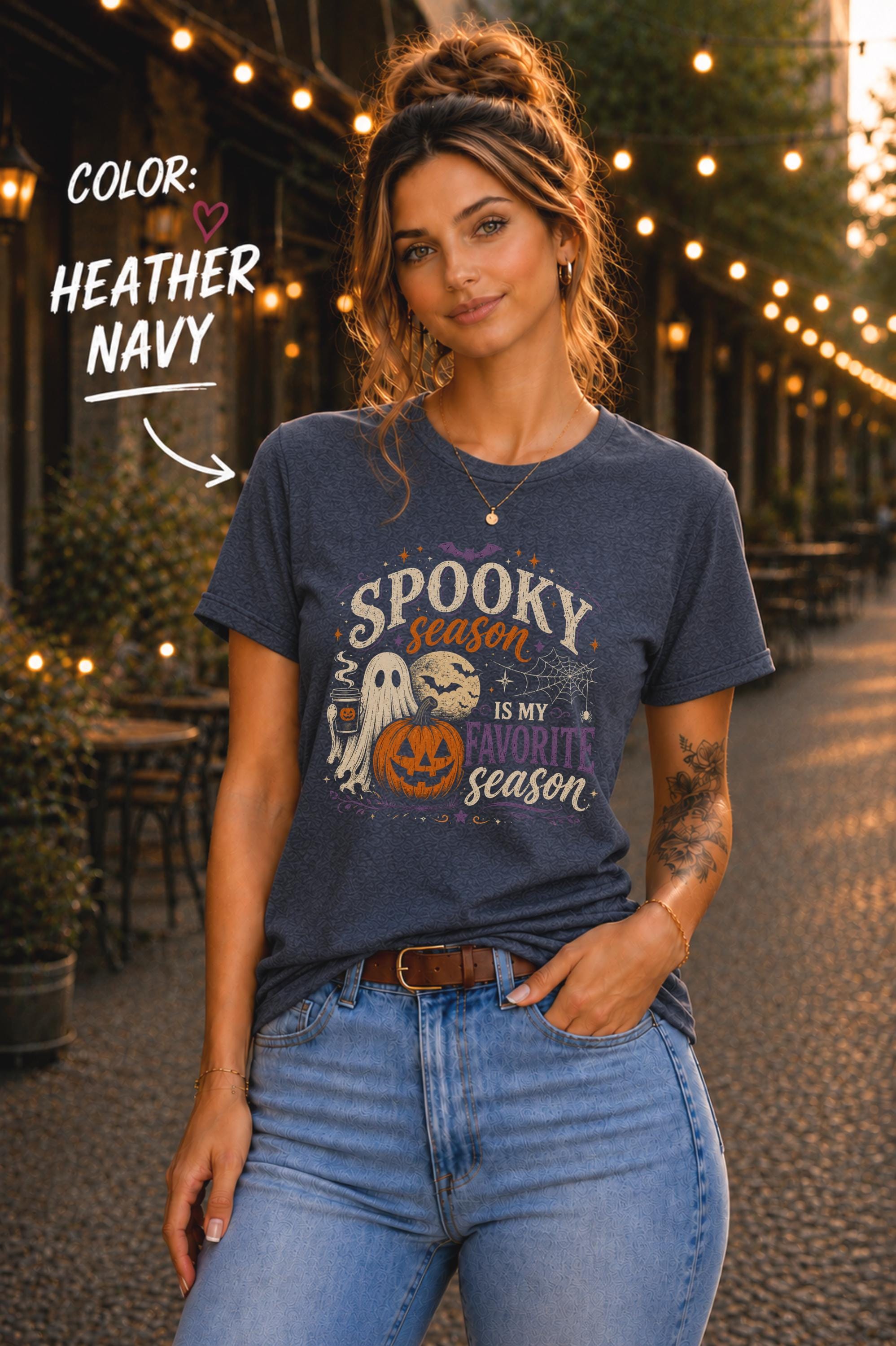 Woman wearing a Bella+Canvas 3001 Heather Navy unisex T-shirt featuring a vintage Halloween design with a cute ghost, pumpkin, spiderweb, full moon, and the phrase "Spooky Season Is My Favorite Season."