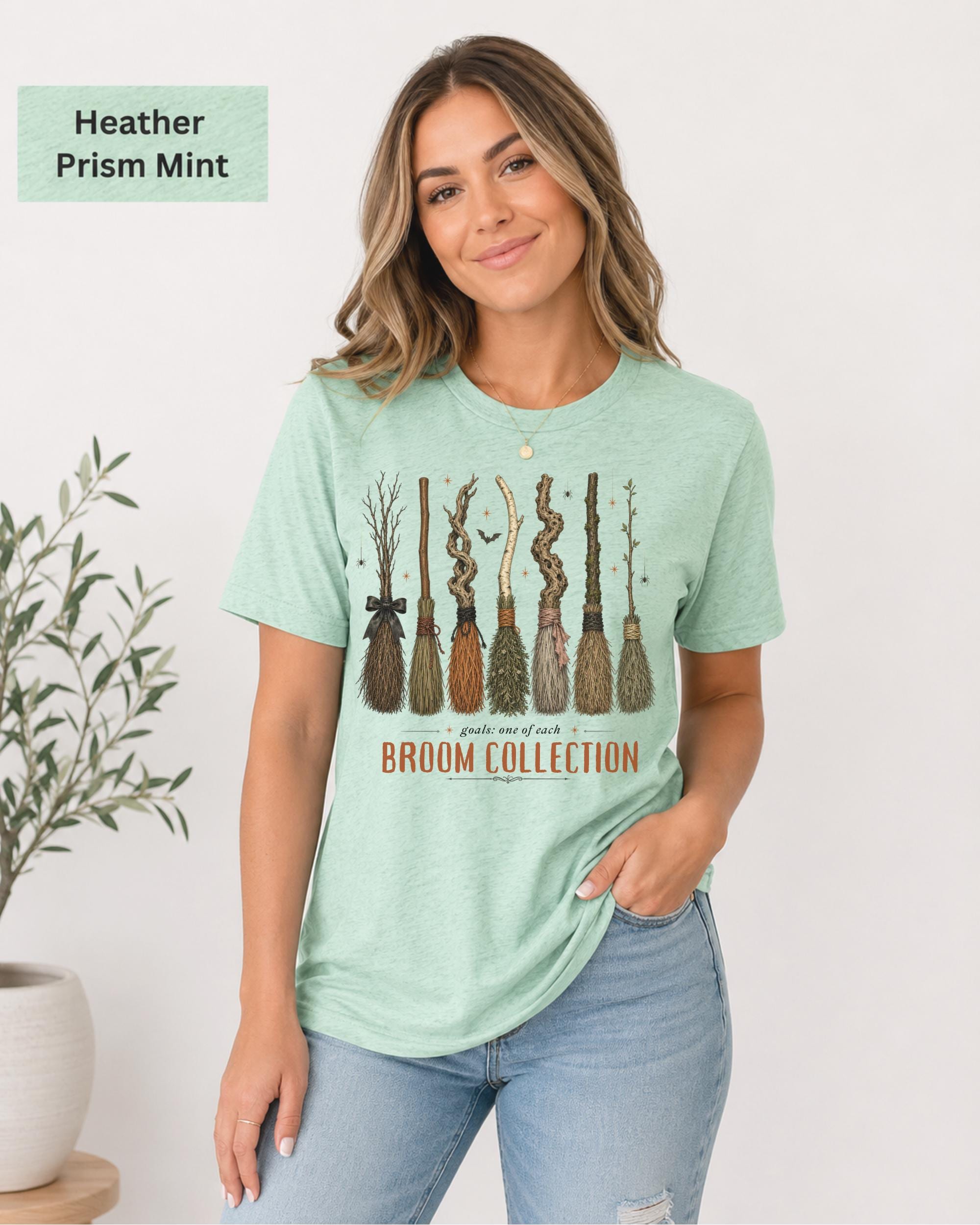 Bella+Canvas 3001 Heather Prism Mint unisex t-shirt featuring a vintage Broom Collection graphic with illustrated witch brooms, earthy autumn colors, and cozy Halloween-inspired artwork.