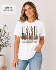 Bella+Canvas 3001 White unisex t-shirt featuring a vintage Broom Collection graphic with illustrated witch brooms, earthy autumn colors, and cozy Halloween-inspired artwork.