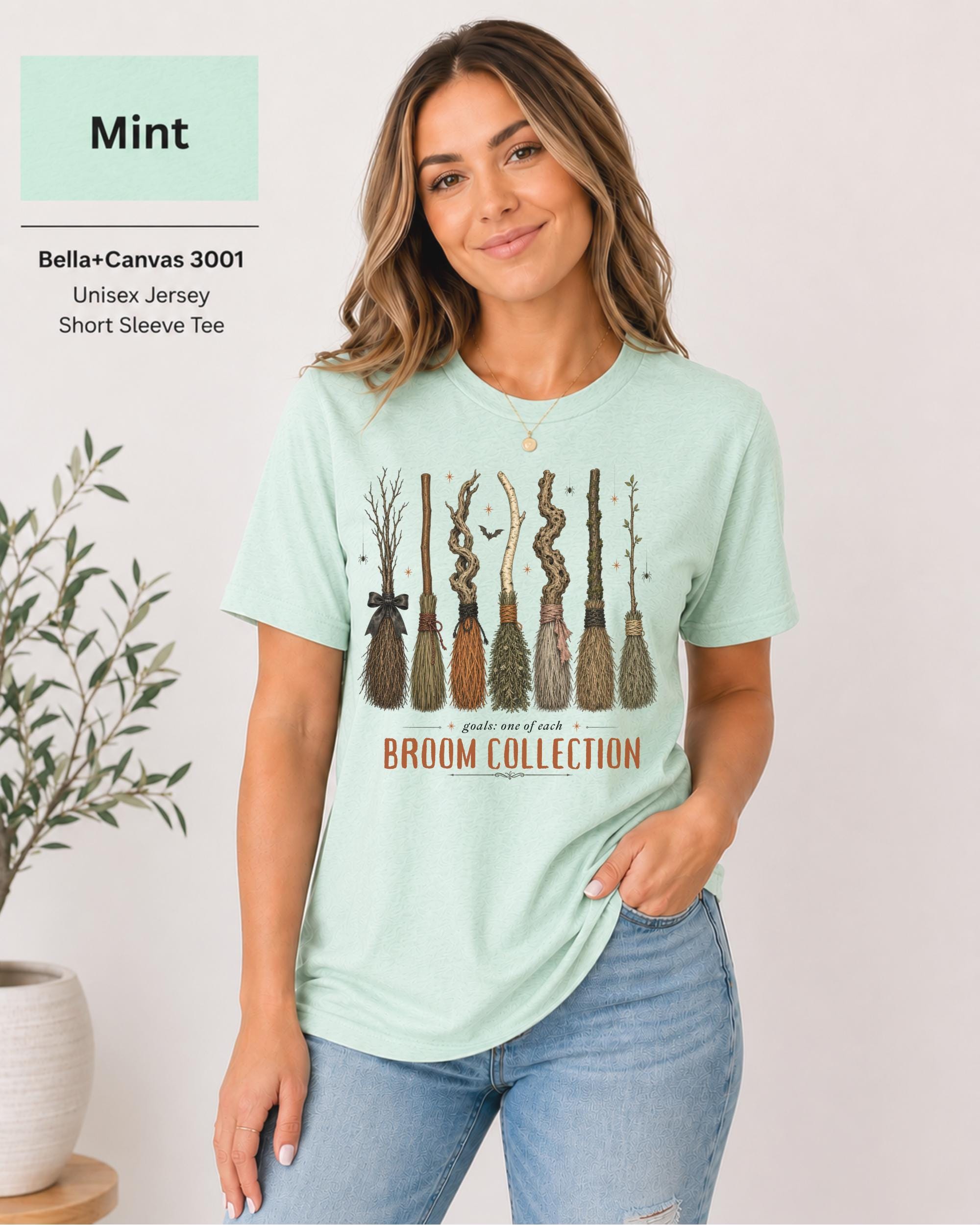 Bella+Canvas 3001 Mint unisex t-shirt featuring a vintage Broom Collection graphic with illustrated witch brooms, earthy autumn colors, and cozy Halloween-inspired artwork.