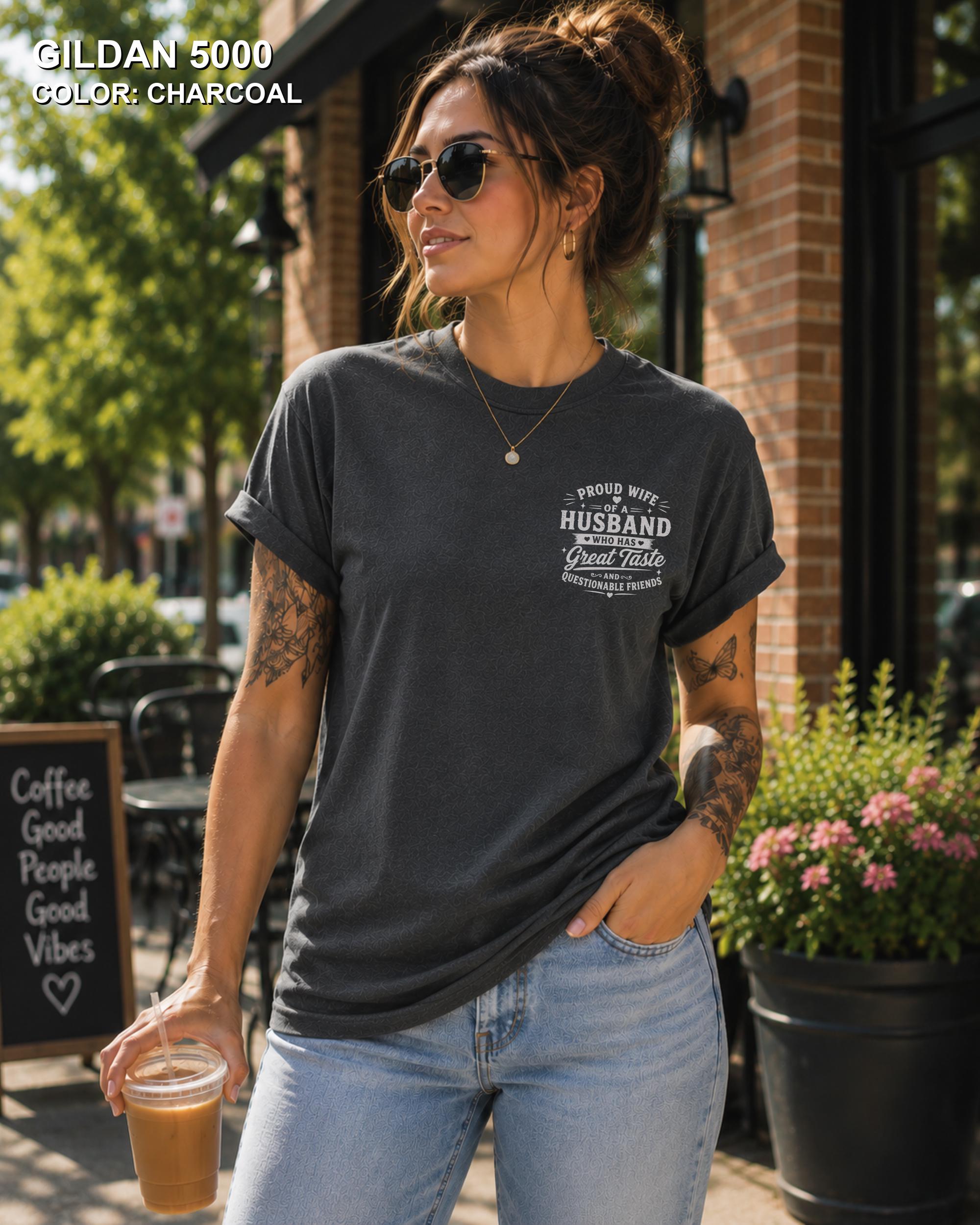 Charcoal Gildan 5000 unisex t-shirt with a small left chest graphic reading "Proud Wife of a Husband Who Has Great Taste and Questionable Friends," funny couple apparel.