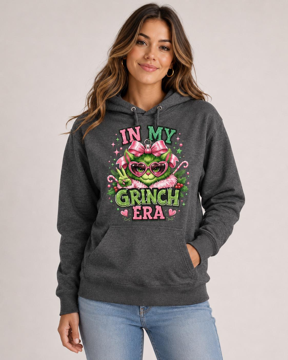 Front view of charcoal heather hoodie with a large pink and green holiday ornament design and festive lettering.