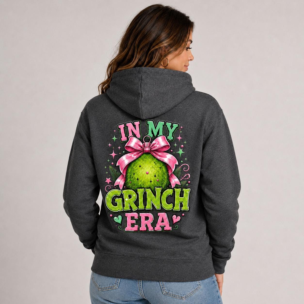 Back view of charcoal heather hoodie with a large pink and green holiday ornament design and festive lettering.
