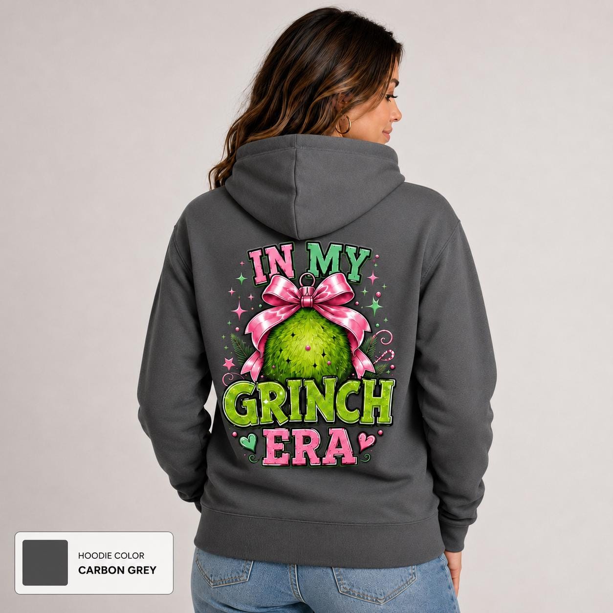 Back view of carbon grey hoodie featuring a large festive ornament graphic with pink bow and green holiday character.