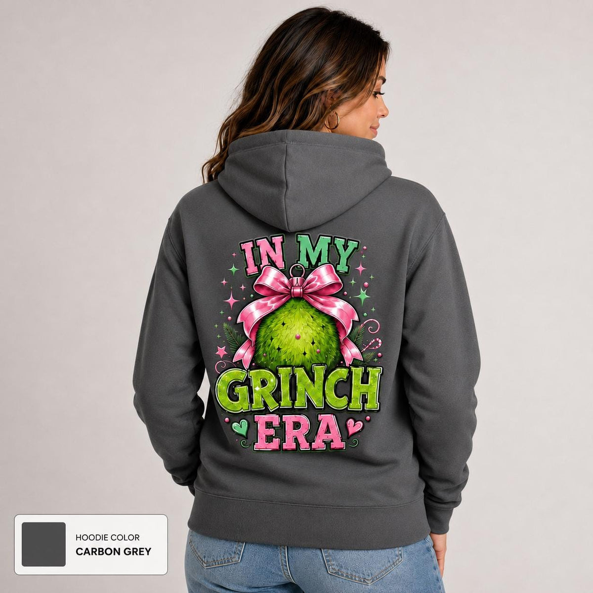 Back view of carbon grey hoodie featuring a large festive ornament graphic with pink bow and green holiday character.