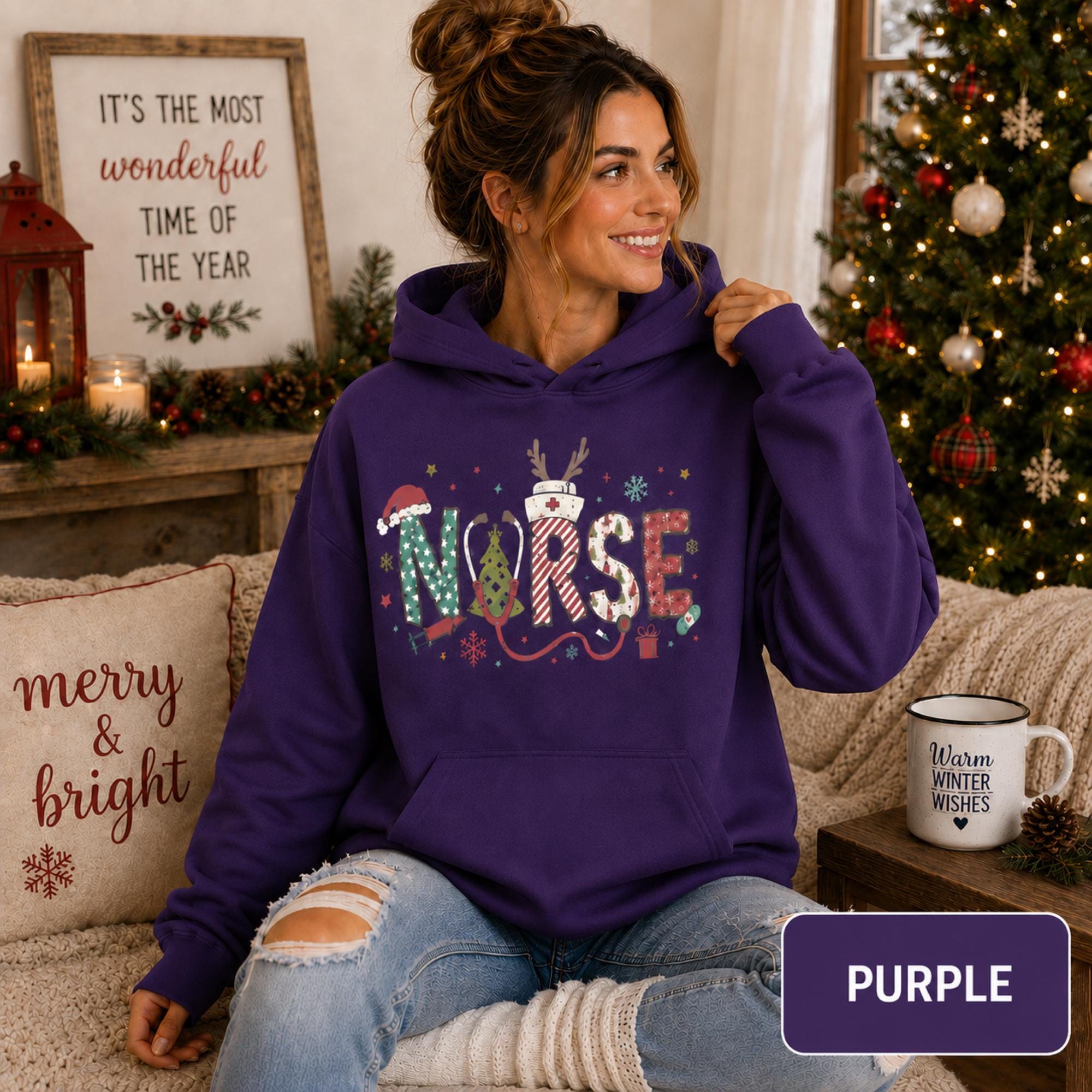 Female model wearing a purple Christmas nurse hoodie with colorful festive NURSE lettering in a cozy holiday living room.