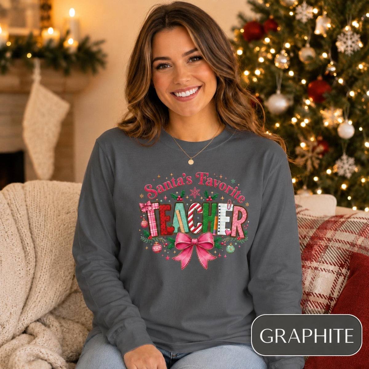 Comfort Colors 6014 long sleeve shirt featuring a colorful Santa’s Favorite Teacher Christmas design with festive lettering, holly, ornaments, school supplies, and a large pink bow.