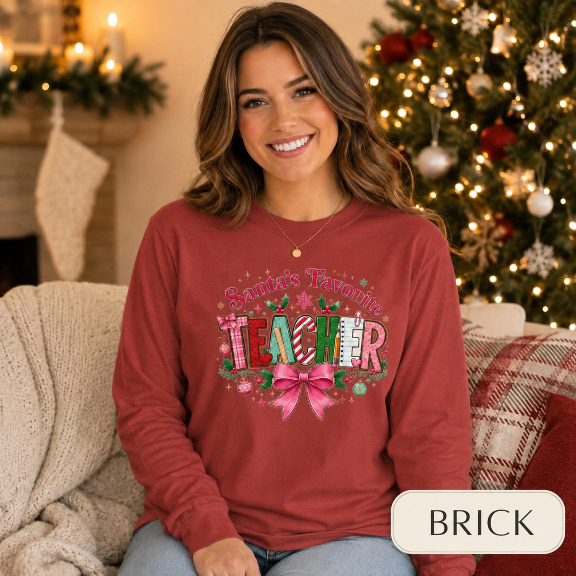 Comfort Colors 6014 long sleeve shirt featuring a colorful Santa’s Favorite Teacher Christmas design with festive lettering, holly, ornaments, school supplies, and a large pink bow.