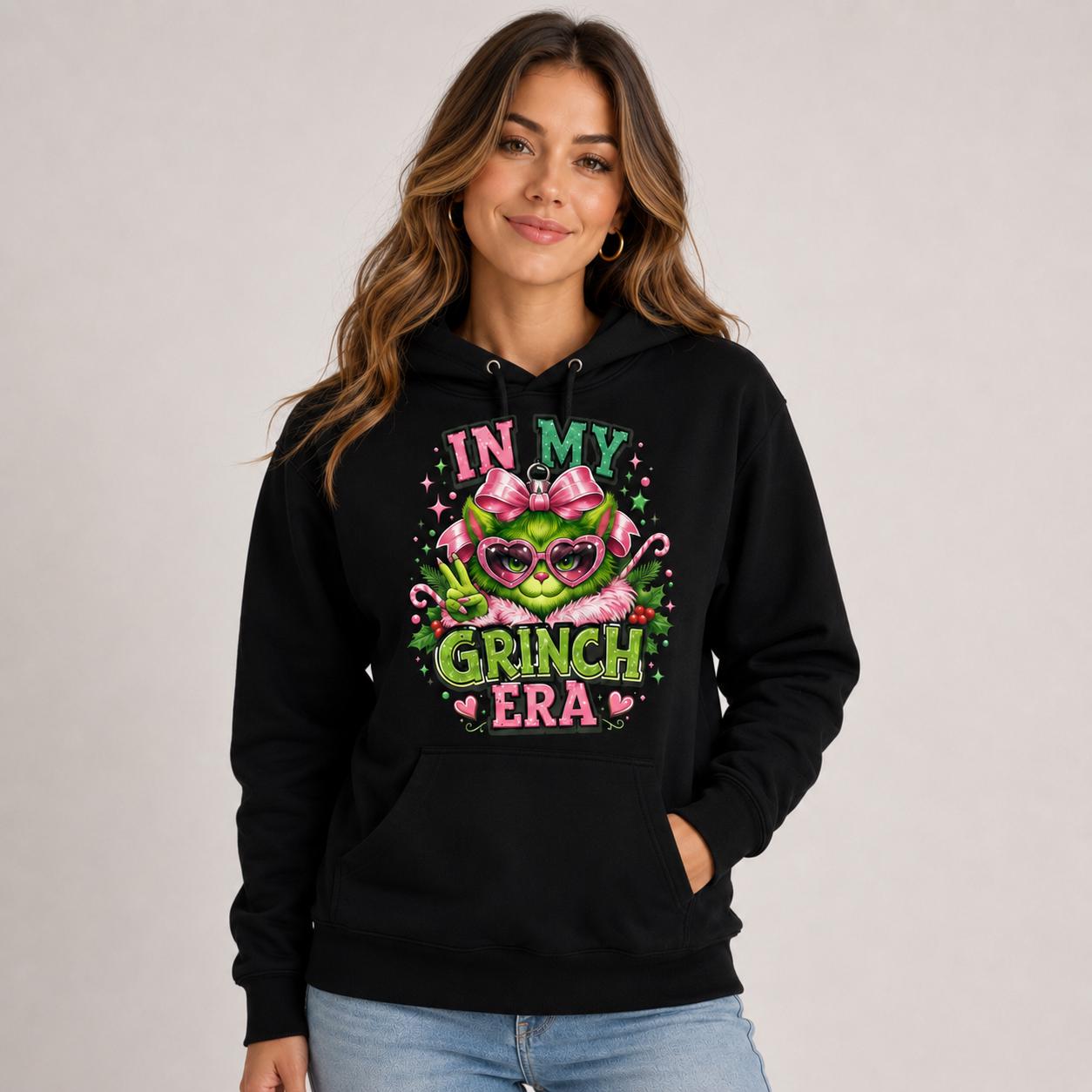 Cotton Heritage M2580 hoodie featuring a pink and green holiday character design with In My Grinch Era text on the front.