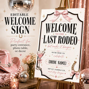 Editable Last Rodeo welcome sign on a gold easel with pink cowboy hat, disco balls, roses and sparkling party decor.