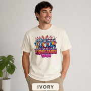Male model wearing a ivory T-shirt featuring stylish cartoon rabbits and bold “Let the Tariff Games Begin” text.