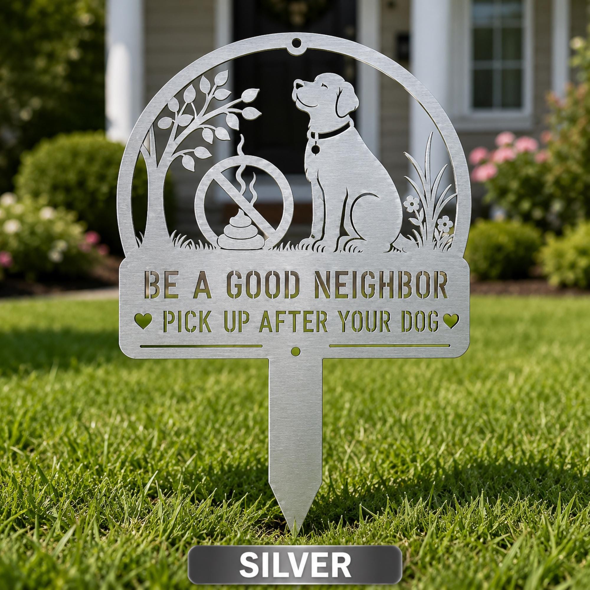 Silver metal yard stake sign with dog silhouette and the text Be a Good Neighbor Pick Up After Your Dog displayed on a front lawn.