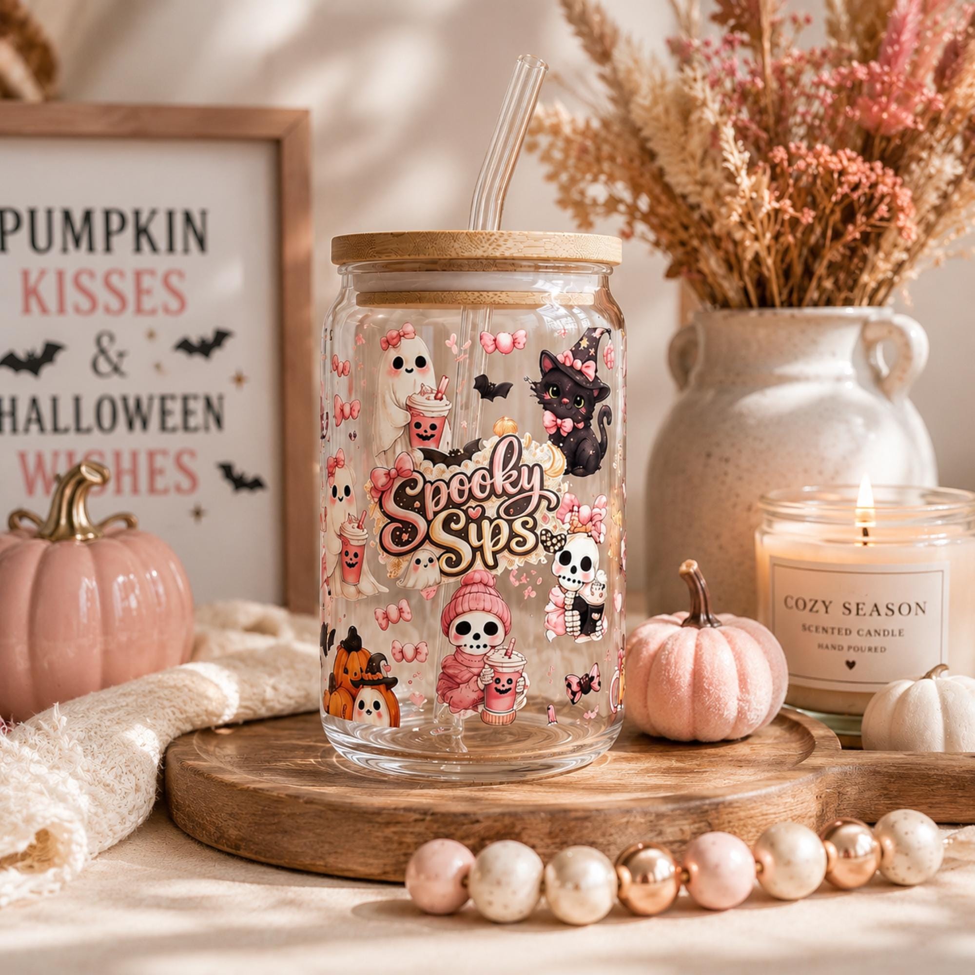 16oz Halloween glass tumbler filled with iced coffee featuring cute ghost, black cat and skeleton coquette Halloween artwork.