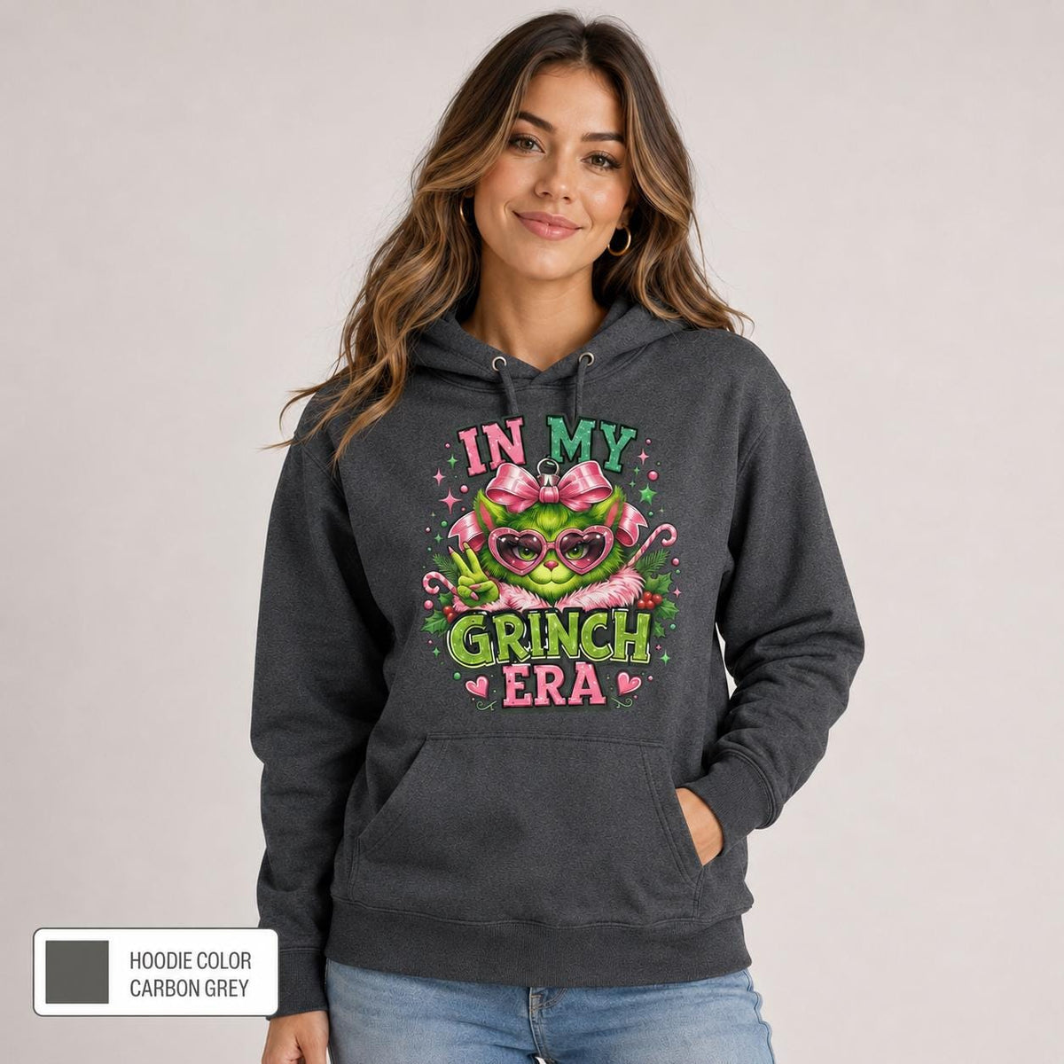 Female model wearing a carbon grey hoodie with a vibrant pink and green holiday design and color label shown.