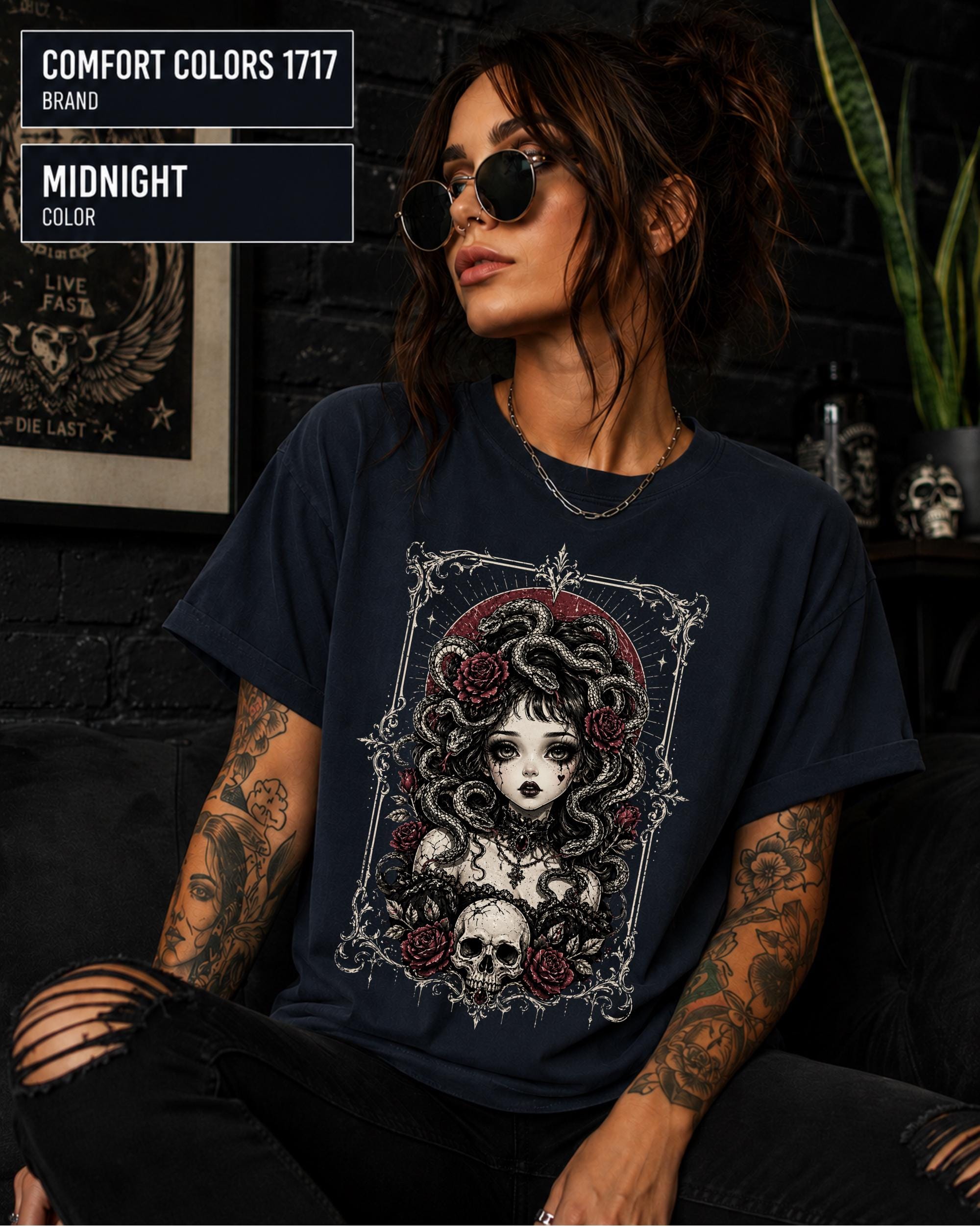 Woman wearing a Midnight Comfort Colors 1717 T-shirt featuring a gothic Medusa-inspired woman with snakes, dark roses, ornate framing, and a skull design.