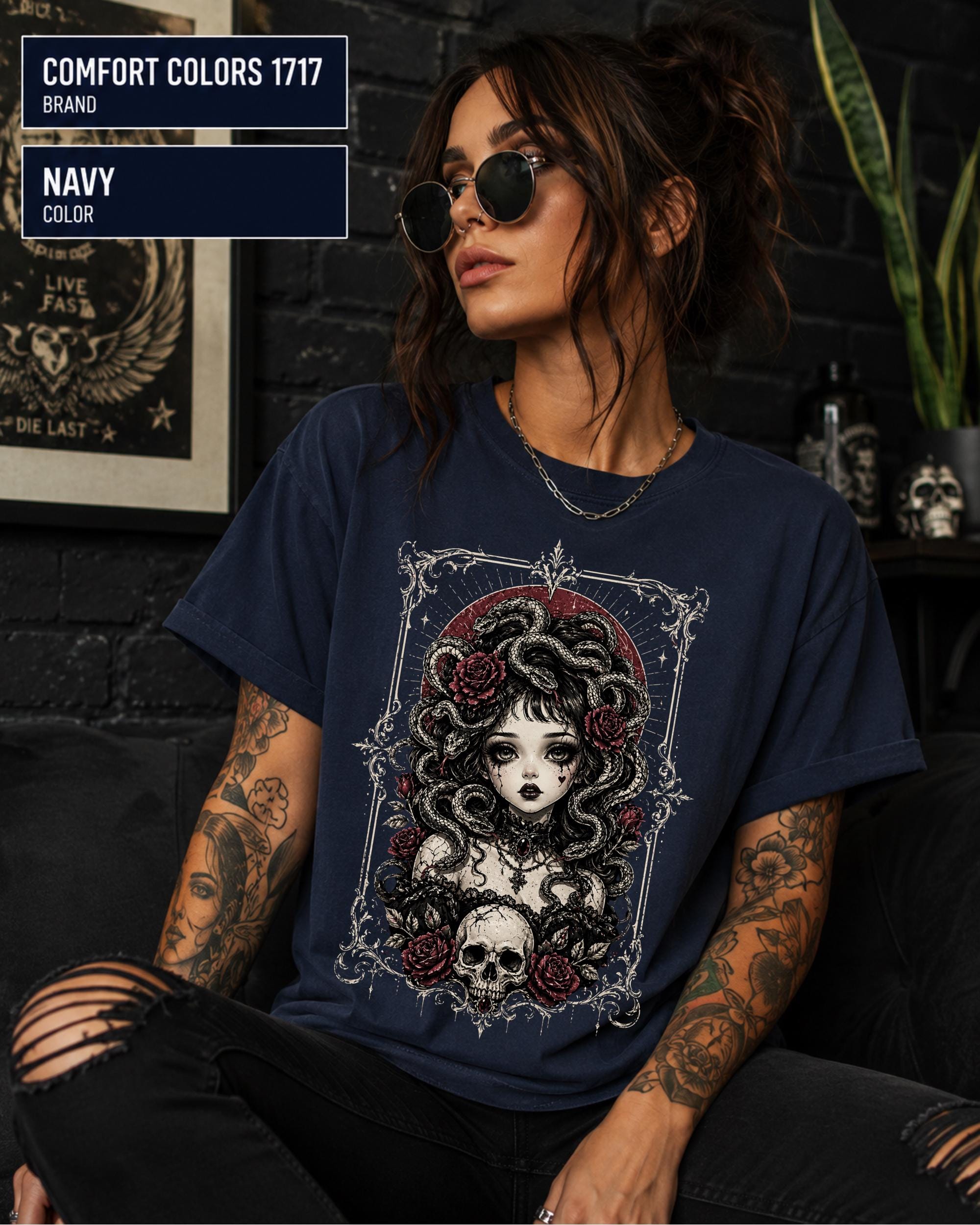 Woman wearing a Navy Comfort Colors 1717 T-shirt featuring a gothic Medusa-inspired woman with snakes, dark roses, ornate framing, and a skull design.