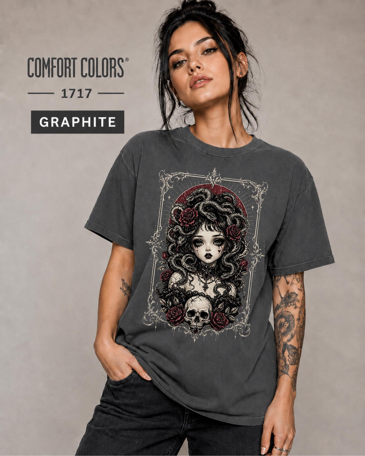 Woman wearing a Graphite Comfort Colors 1717 T-shirt featuring a gothic Medusa-inspired woman with snakes, dark roses, ornate framing, and a skull design.