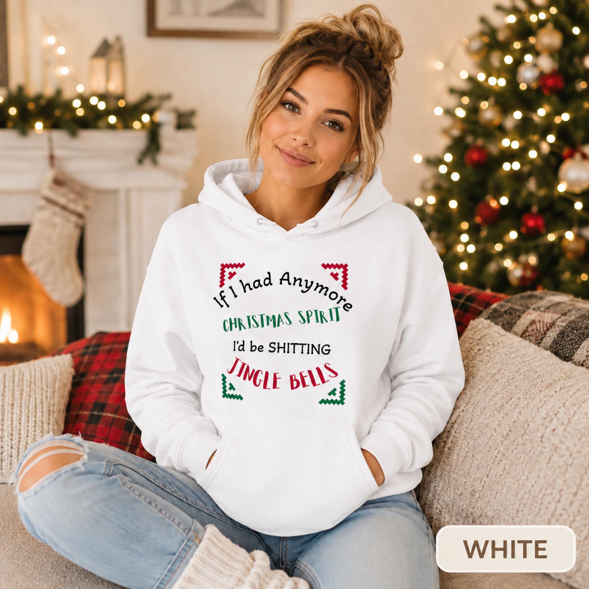 Female model wearing a white Christmas hoodie reading “If I had anymore Christmas spirit, I’d be shitting jingle bells” in a cozy holiday room.