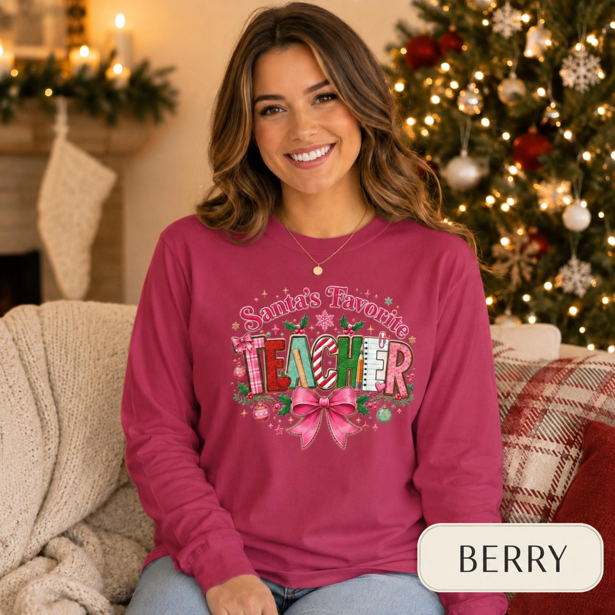 Comfort Colors 6014 long sleeve shirt featuring a colorful Santa’s Favorite Teacher Christmas design with festive lettering, holly, ornaments, school supplies, and a large pink bow.