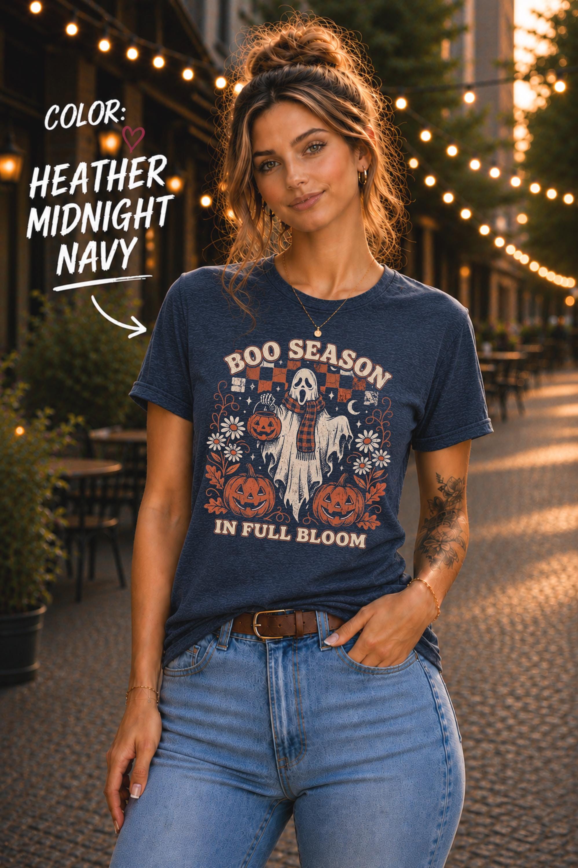 Heather Midnight navy spooky season graphic tee with a scarf-wearing ghost holding a jack-o’-lantern candy bucket.