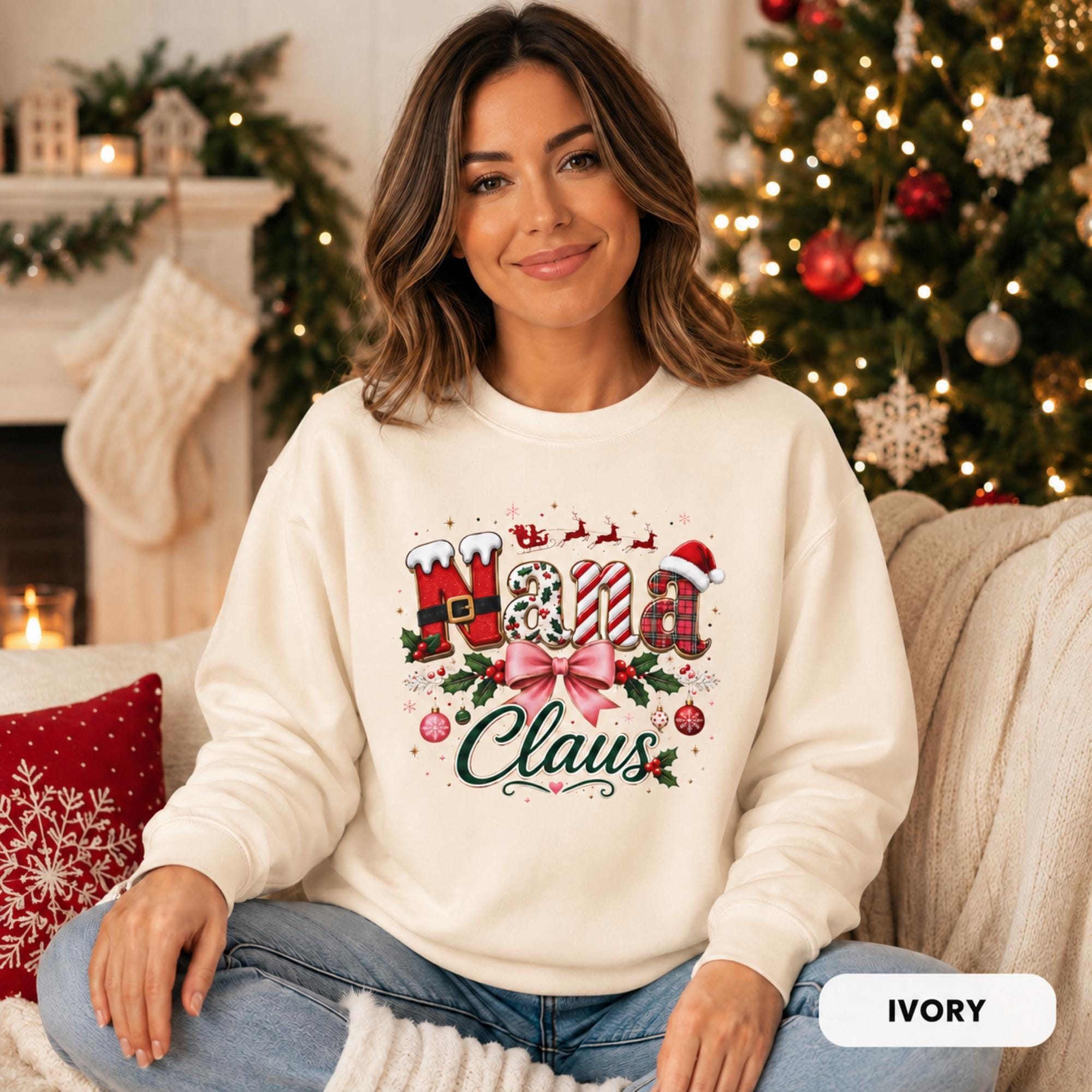 Female model wearing an ivory Comfort Colors crewneck featuring a festive “Nana Claus” Christmas design with a pink bow, holly, ornaments, and holiday lettering.