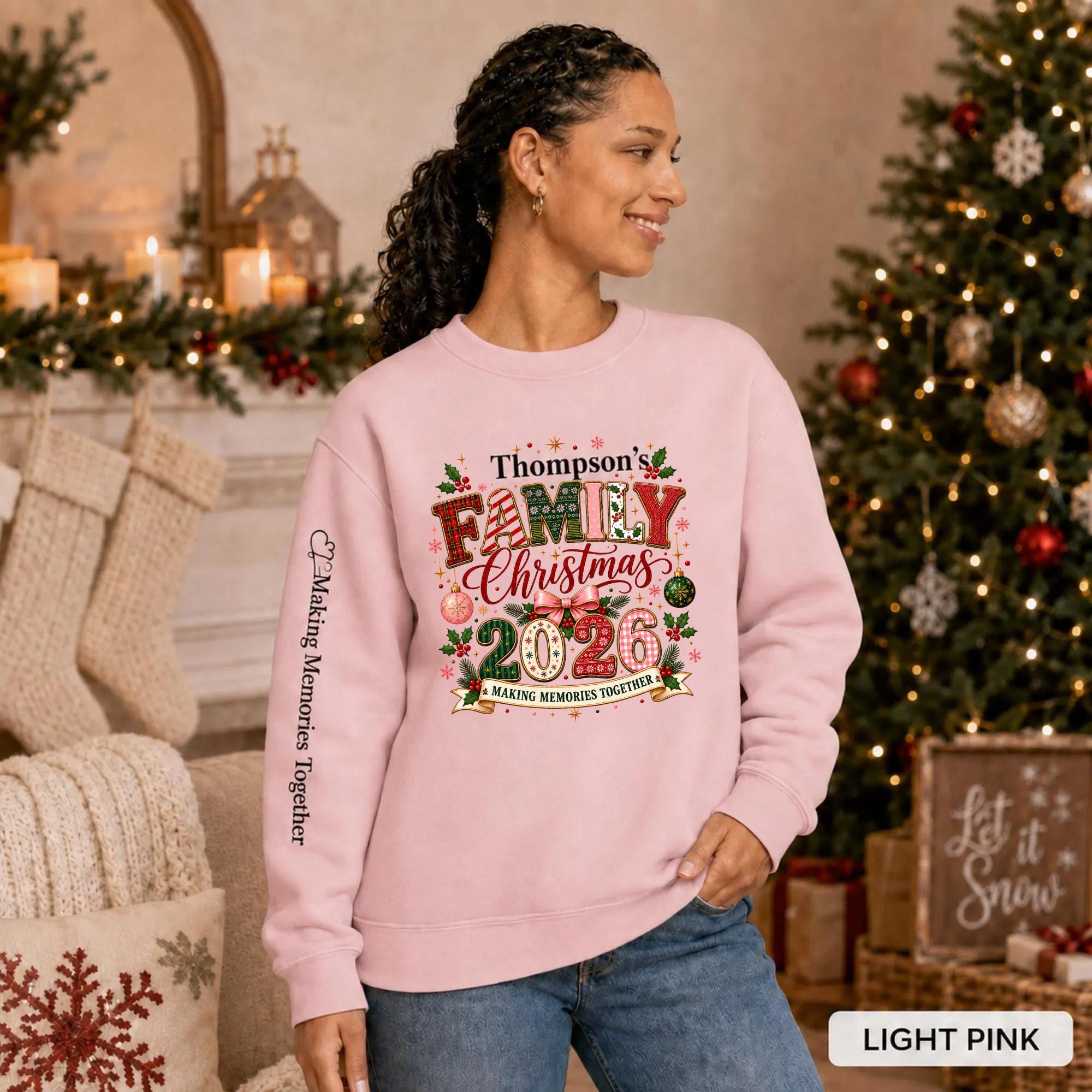 Light Pink Christmas crewneck featuring a personalized Thompson’s Family Christmas 2026 design with festive lettering and sleeve text.
