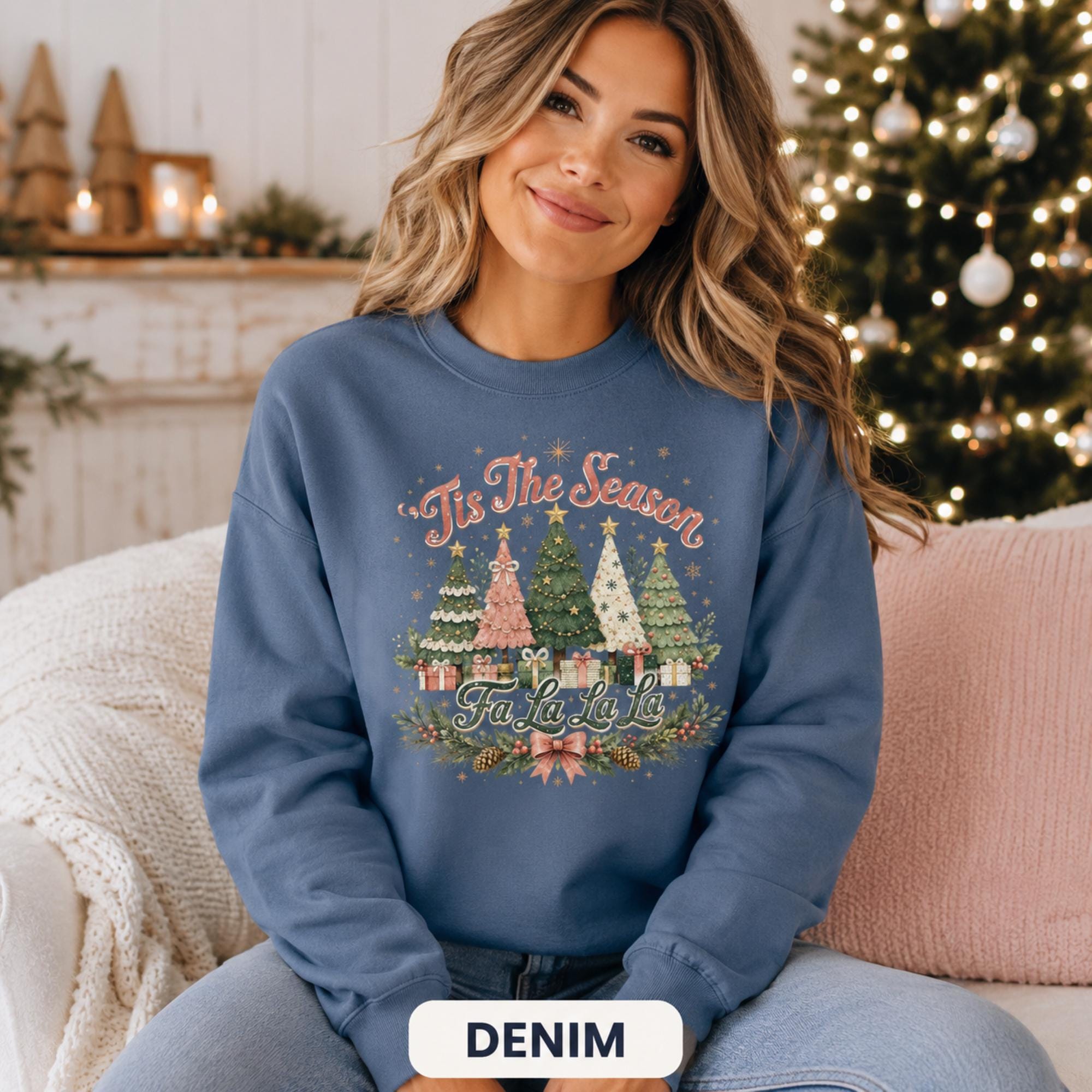 Woman wearing a denim blue Christmas sweatshirt with vintage Christmas trees and 'Tis the Season Fa La La La' design.