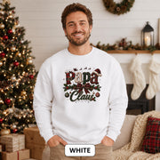 Man wearing a white Papa Claus Christmas sweatshirt with festive plaid lettering, holly, ornaments, and Santa hat.