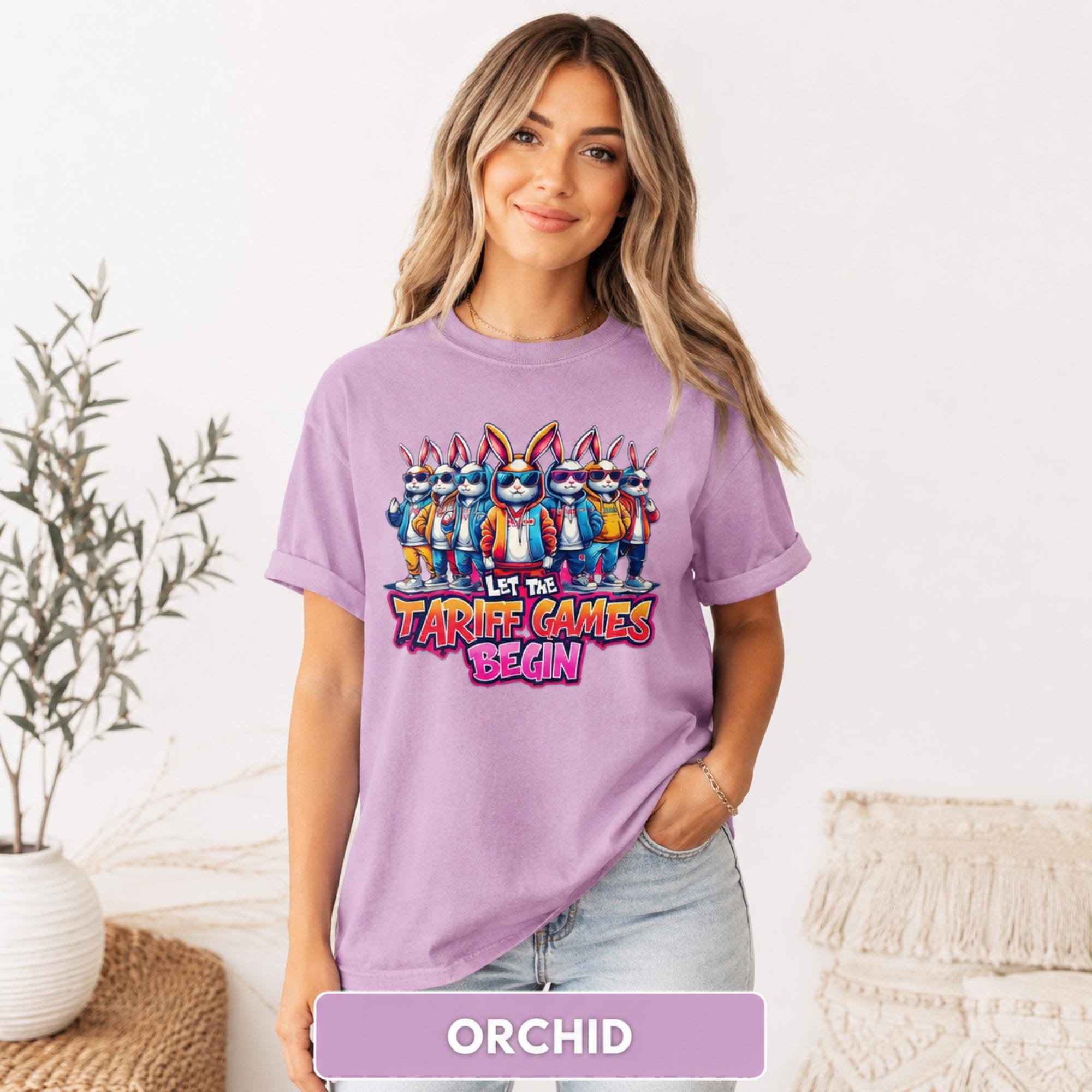 Female model wearing an orchid purple T-shirt with a colorful bunny group and playful tariff-themed graphic.