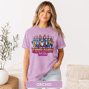 Female model wearing an orchid purple T-shirt with a colorful bunny group and playful tariff-themed graphic.