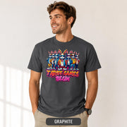 Male model wearing a graphite T-shirt featuring stylish cartoon rabbits and bold “Let the Tariff Games Begin” text.