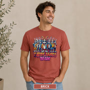 Male model wearing a brick T-shirt featuring stylish cartoon rabbits and bold “Let the Tariff Games Begin” text.