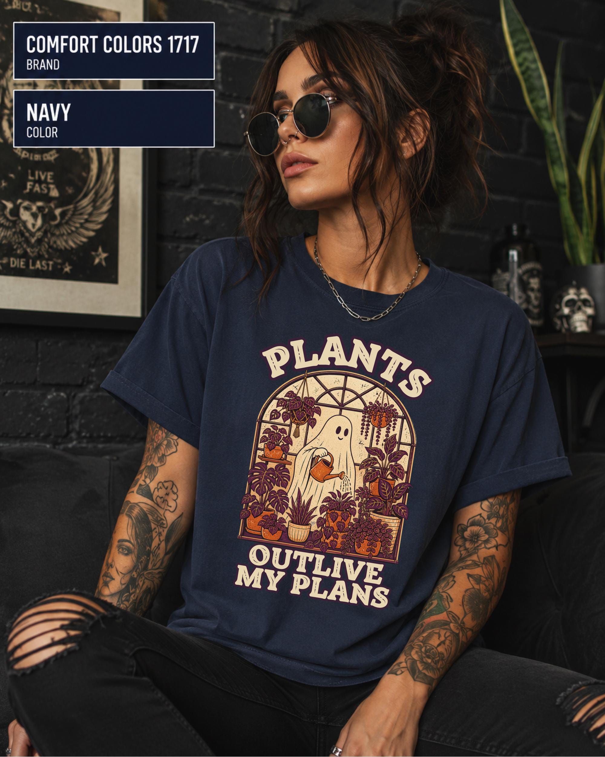 Model wearing Comfort colors tshirt in the color navy featuring a Retro cream and orange ghost watering purple houseplants inside a greenhouse with the words Plants Outlive My Plans.