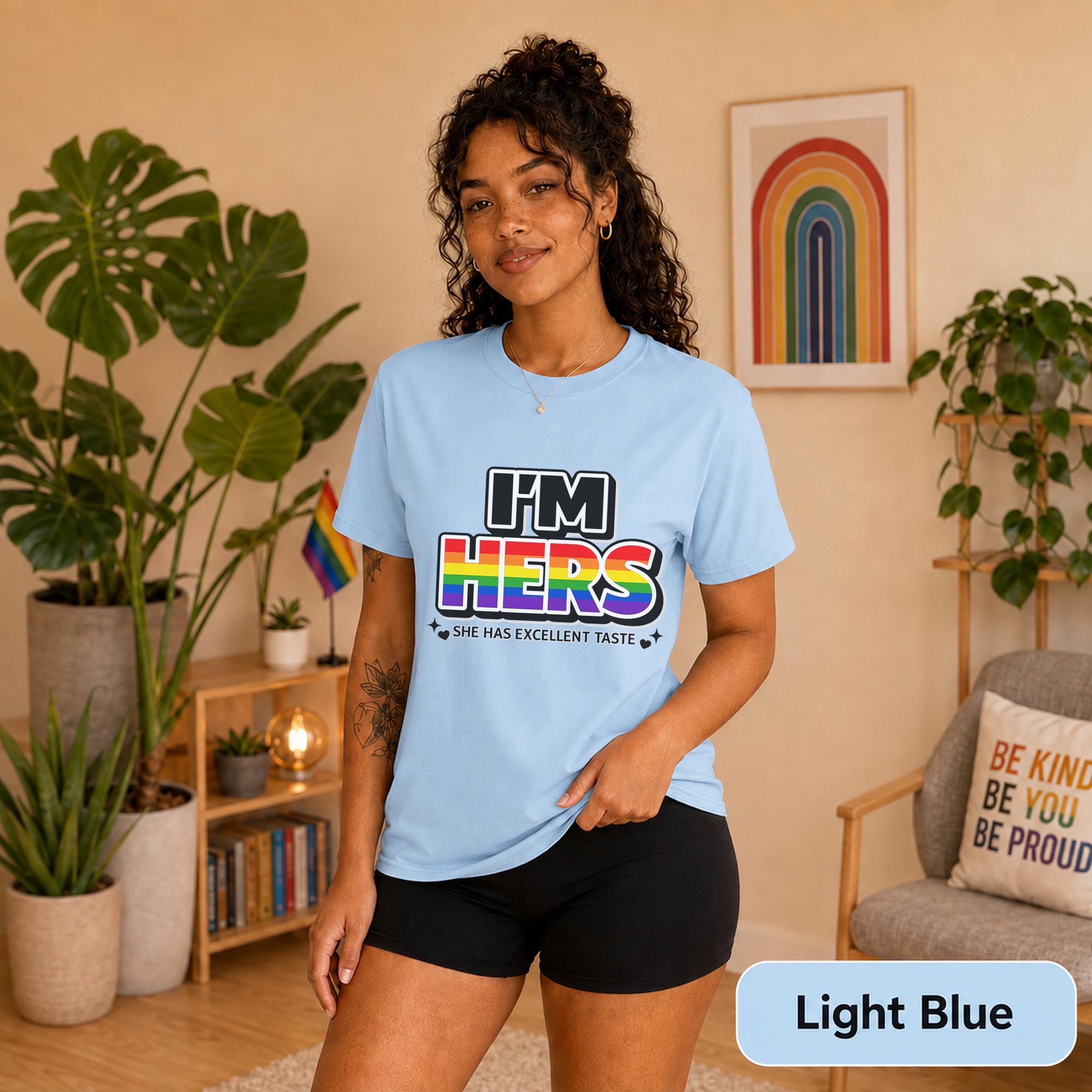 Matching lesbian shirts styled with black shorts beside rainbow Pride decor.