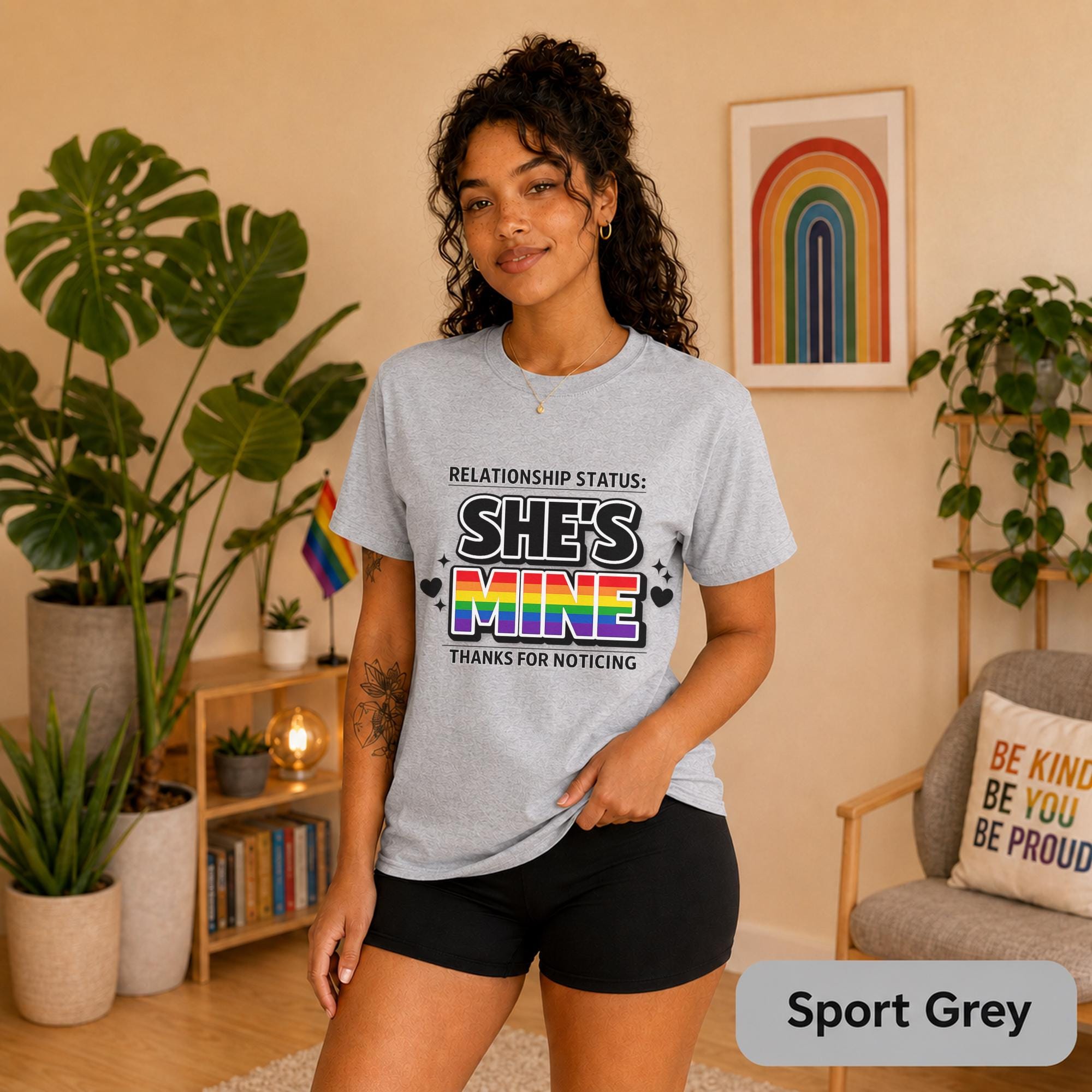 Rainbow couple shirts photographed with plants, Pride flags, and warm neutral decor.