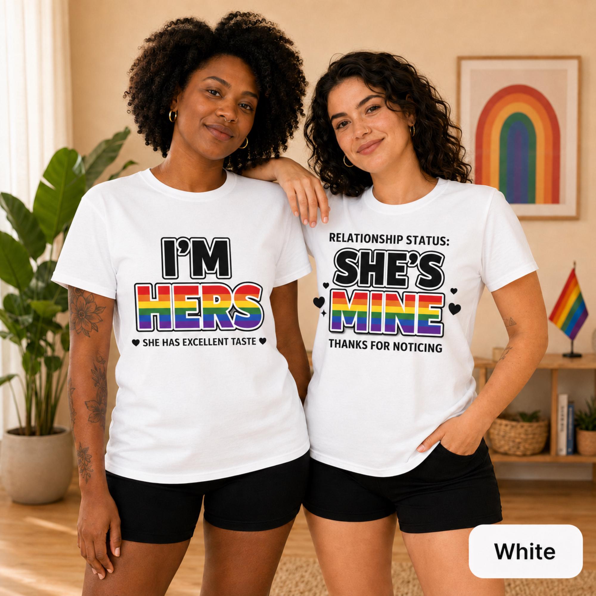 Two women wearing matching white lesbian couple shirts with rainbow I’m Hers and She’s Mine wording.