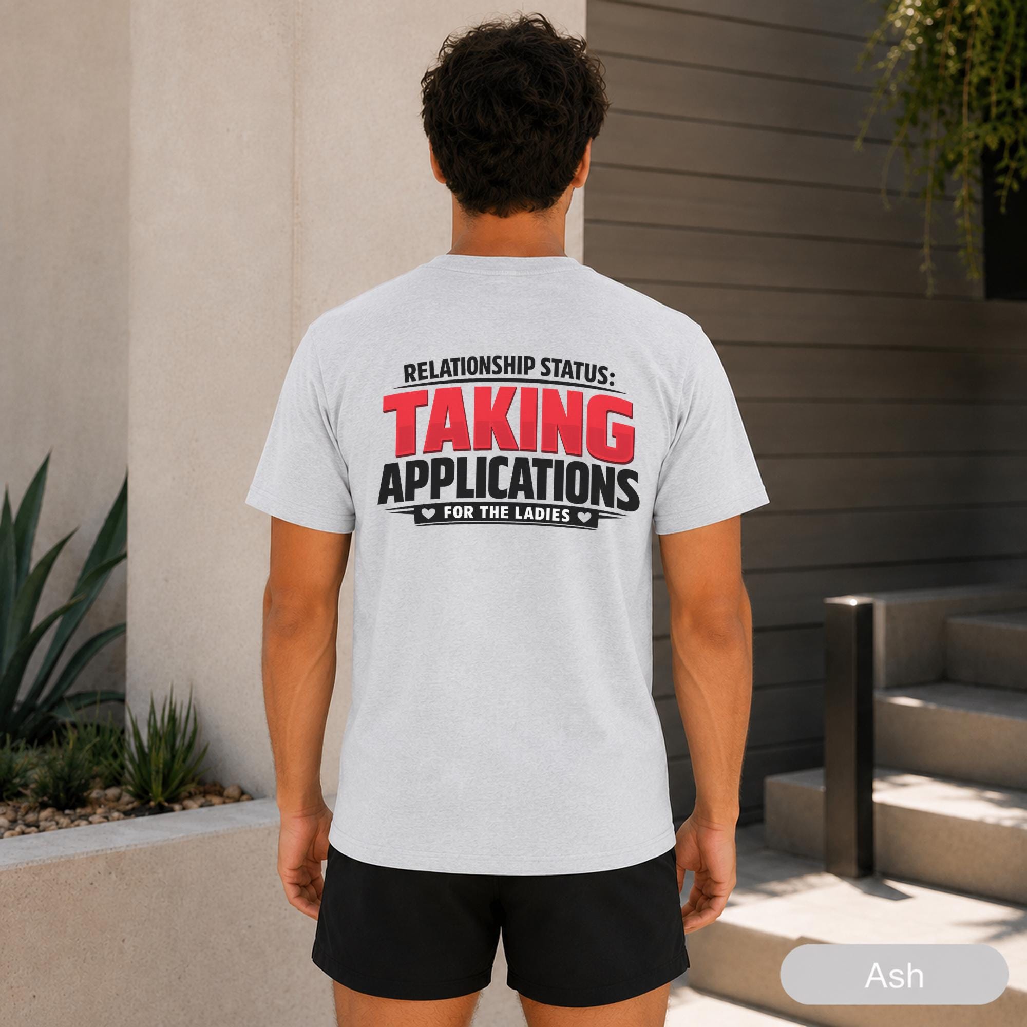 Male model wearing a bold front and back graphic tee with black athletic shorts.