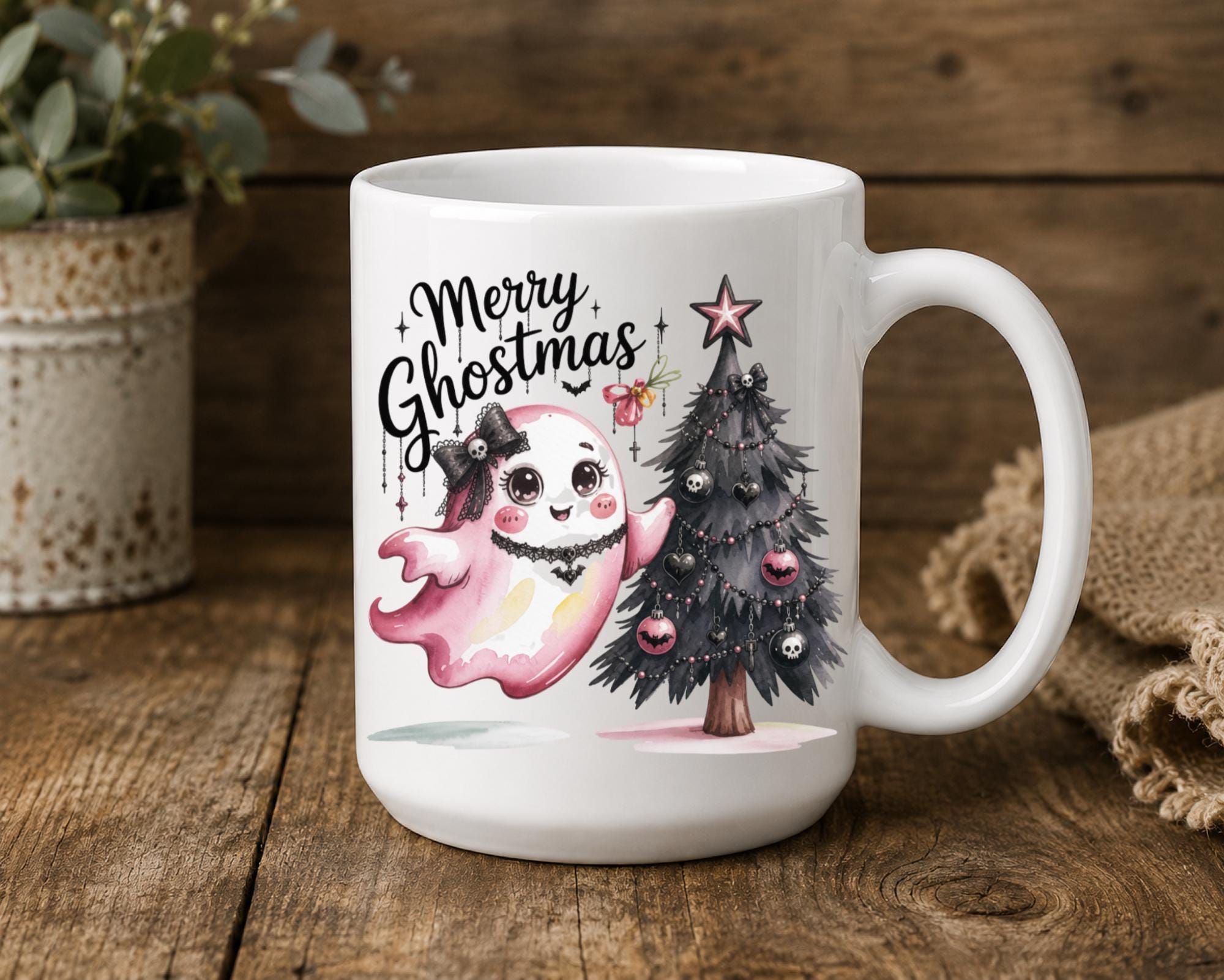 White ceramic Merry Ghostmas mug featuring a cute pink ghost beside a gothic Christmas tree.