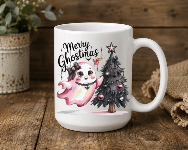 White ceramic Merry Ghostmas mug featuring a cute pink ghost beside a gothic Christmas tree.