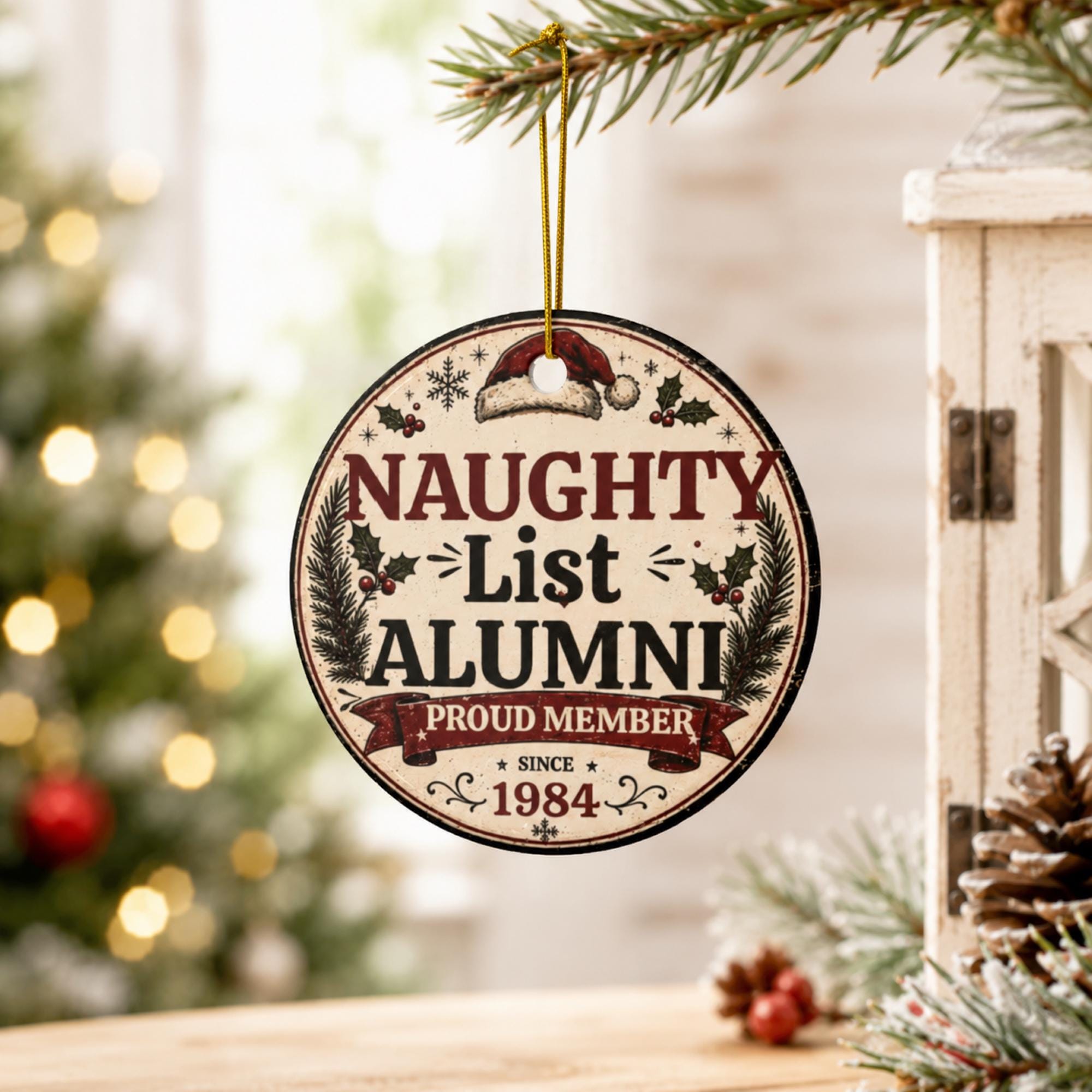 Naughty List Alumni ceramic Christmas ornament hanging on a decorated holiday tree with festive lights.