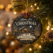 Close-up of a custom coordinates Christmas ornament displaying a winter village scene and personalized location.