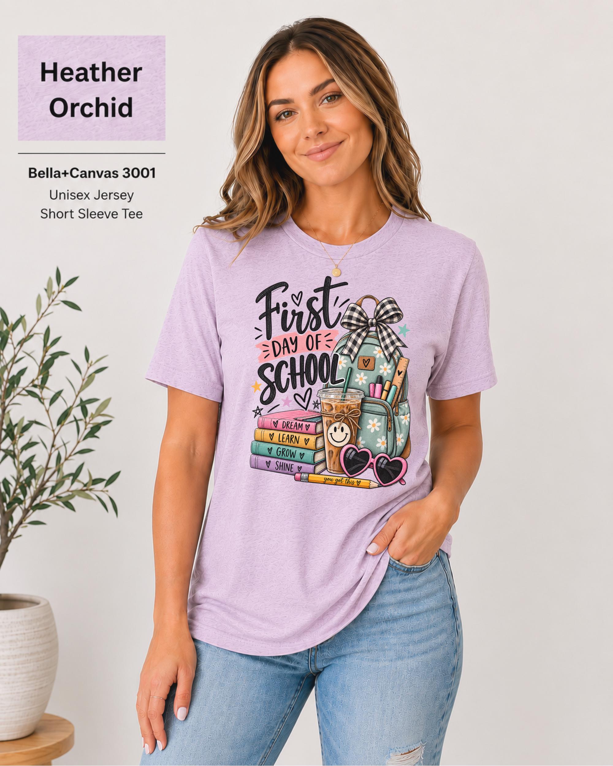 Heather orchid teacher shirt with First Day of School lettering and colorful school supply design.