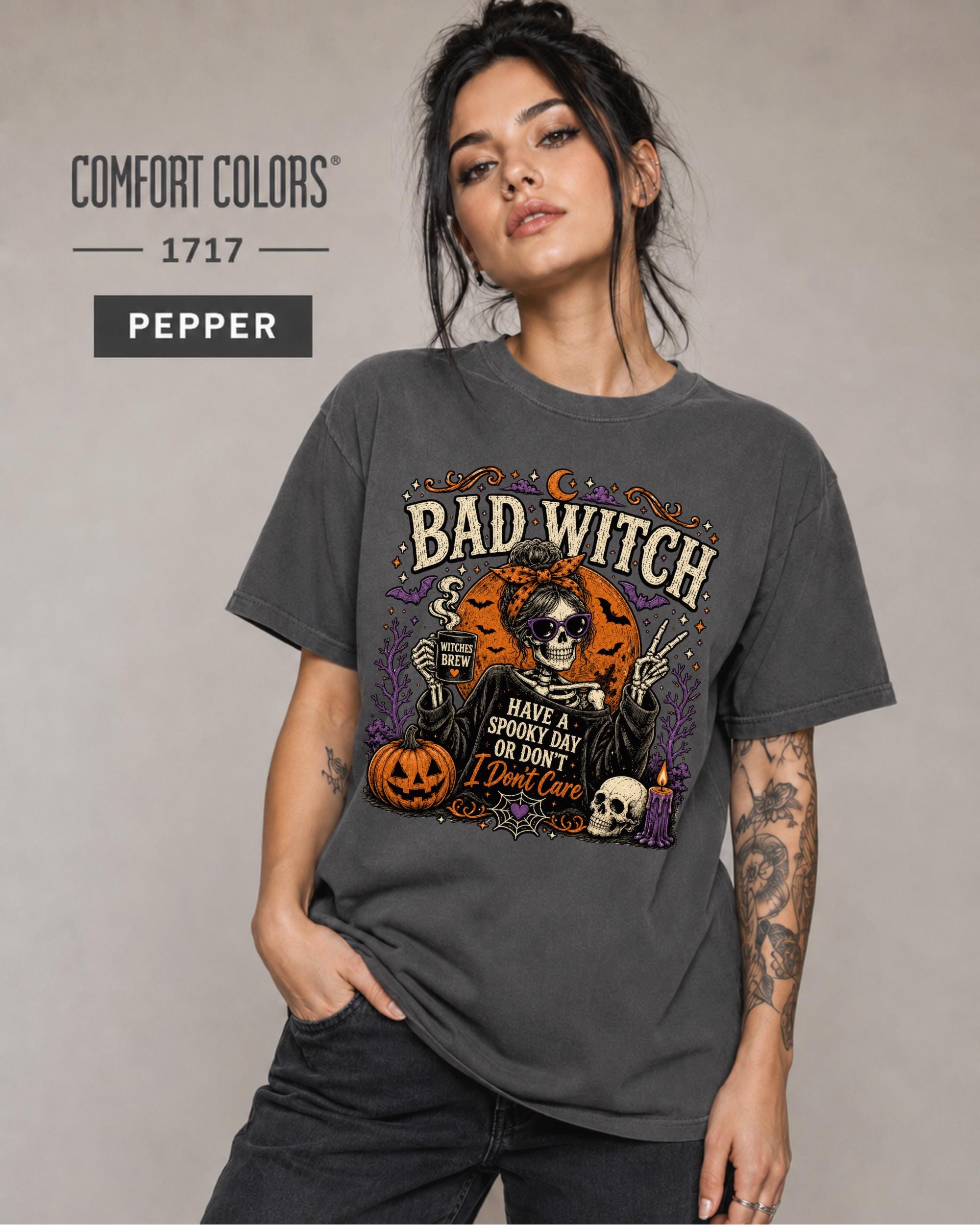Woman wearing a Pepper Comfort Colors 1717 Bad Witch Halloween shirt with skeleton artwork.