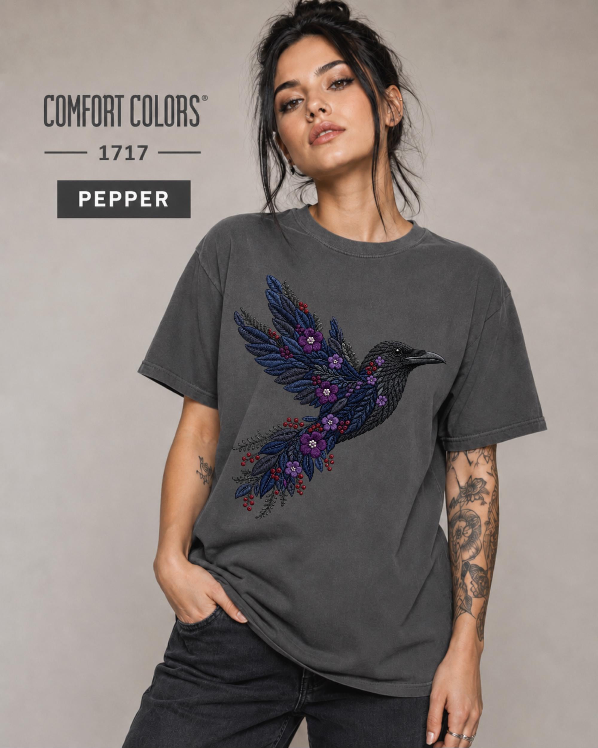 Pepper Comfort Colors 1717 t-shirt featuring a black raven graphic with purple flowers and blue feather details in a gothic botanical style.