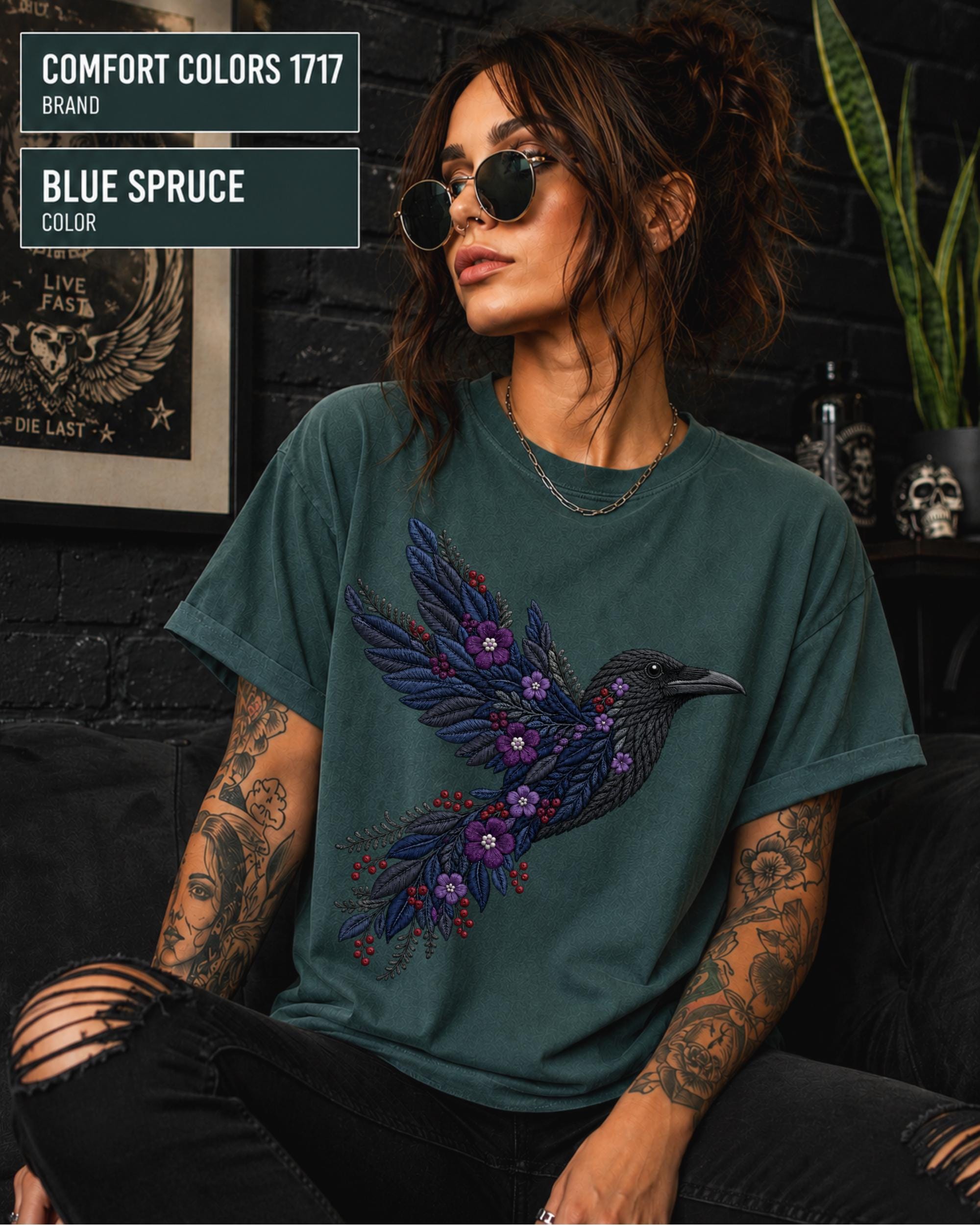 Blue Spruce Comfort Colors 1717 t-shirt featuring a black raven graphic with purple flowers and blue feather details in a gothic botanical style.