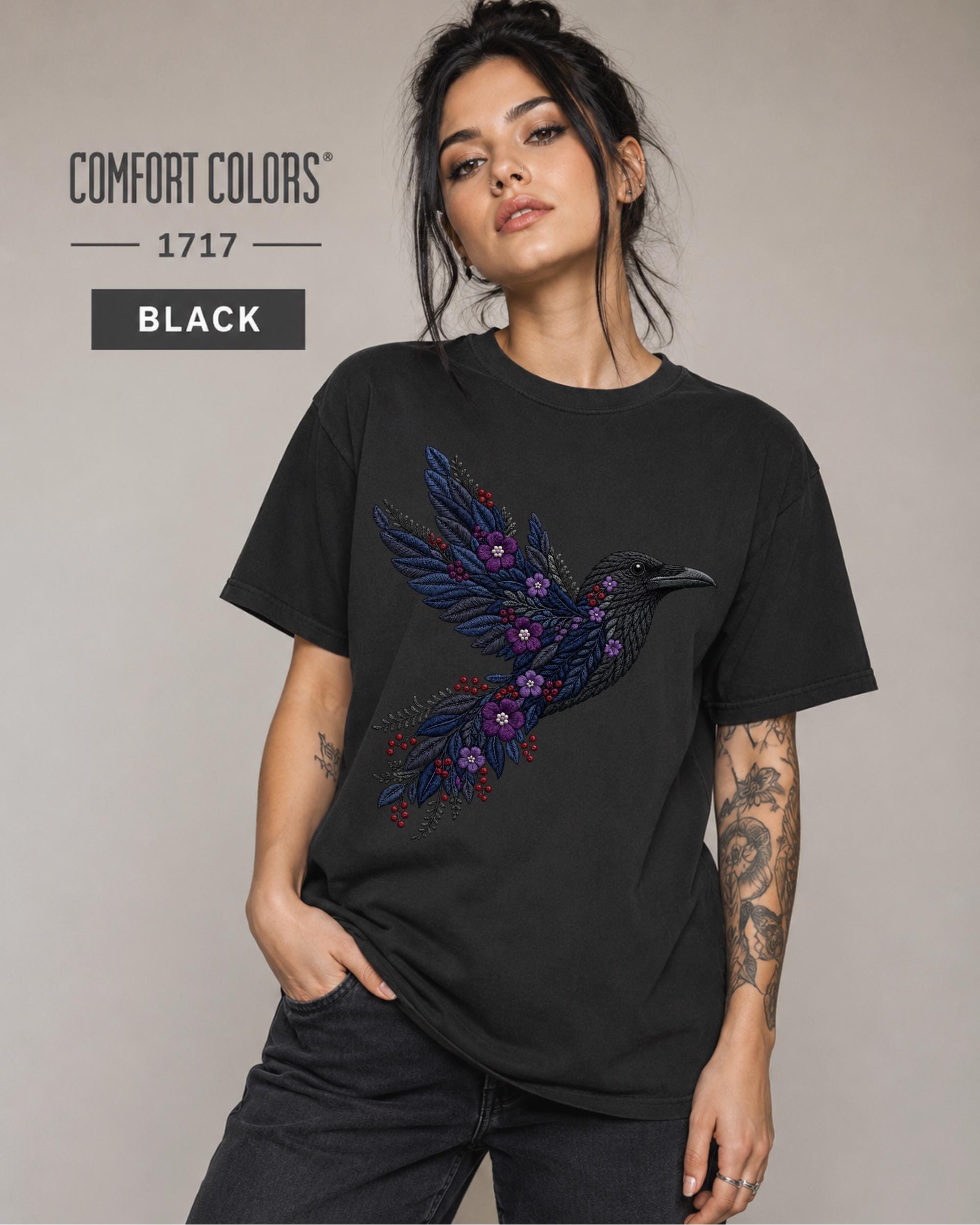 Black Comfort Colors 1717 t-shirt featuring a black raven graphic with purple flowers and blue feather details in a gothic botanical style.