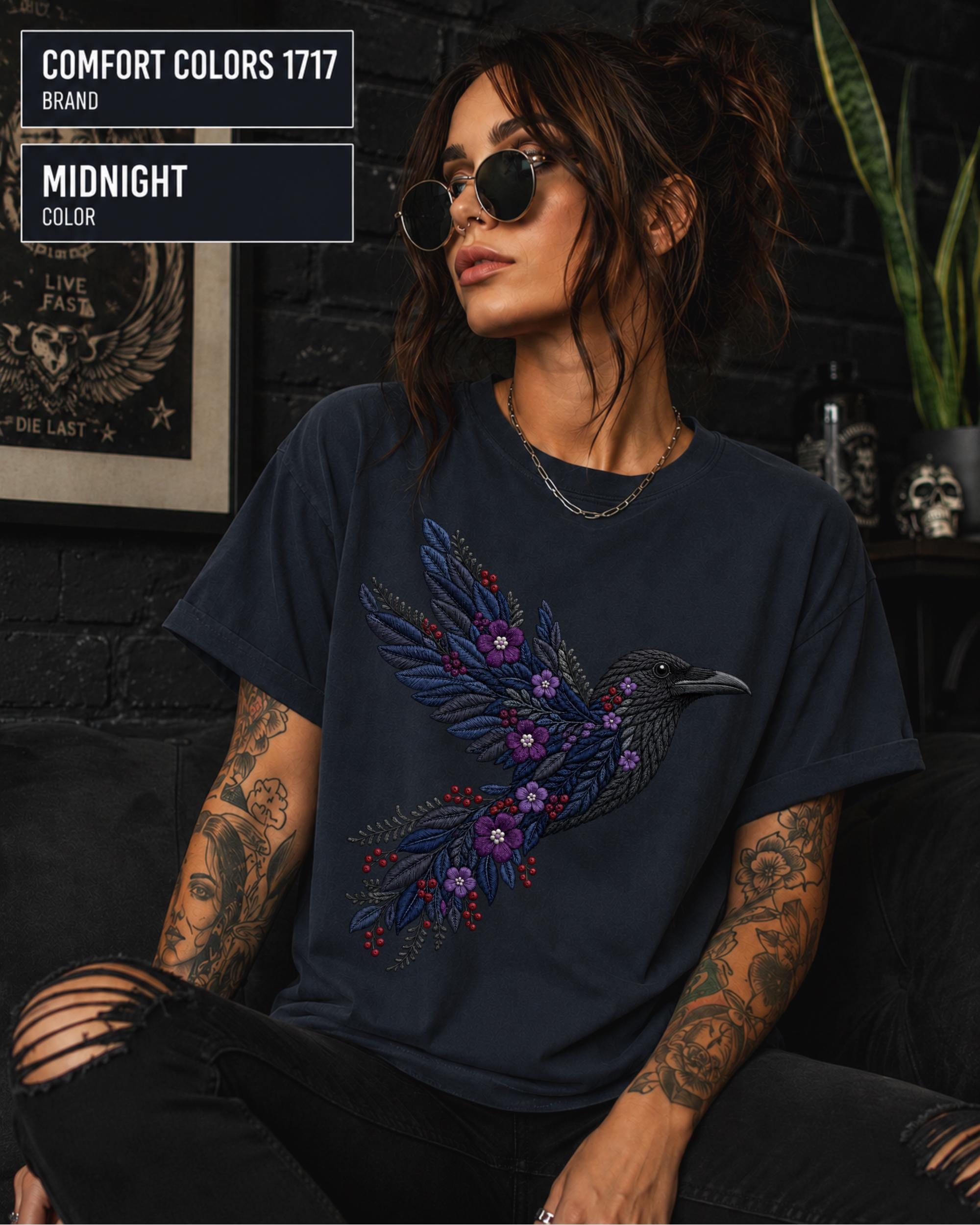 Midnight Comfort Colors 1717 t-shirt featuring a black raven graphic with purple flowers and blue feather details in a gothic botanical style.