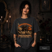 Woman wearing a Pepper Comfort Colors 1717 shirt with Haunted Harvest Bakehouse black cat Halloween design.